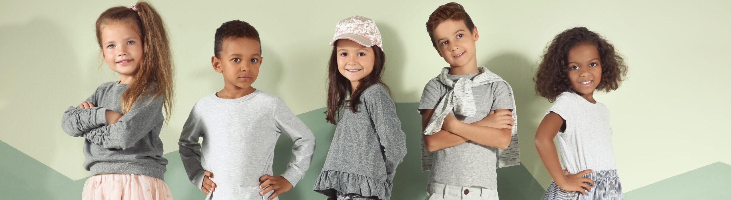 Cute stylish children near color wall