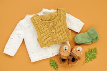 Set of  knitted romper,  jumper, socks and cute baby slippers.  Newborn clothes and accessories. Flat lay, top view